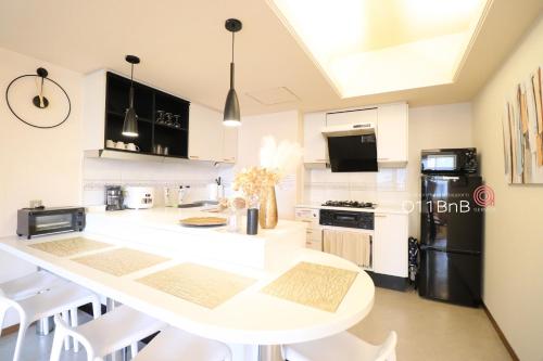 a white kitchen with a white table and chairs at NK BLD4F Sapporo 3LDK 3BR 1 floor 1 room in Sapporo