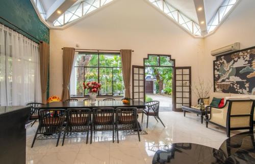 - un salon avec une table à manger et des chaises dans l'établissement Villa Đà Nẵng Gần Biển - Biệt Thự Đà Nẵng, à Đà Nẵng