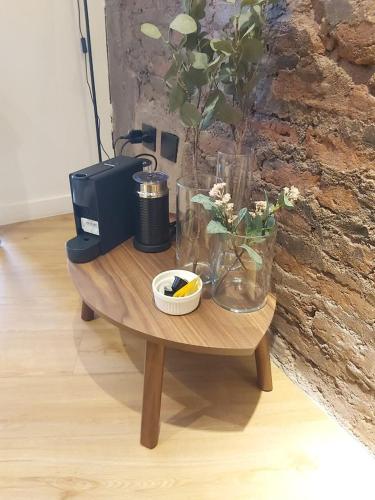 a wooden table with vases and flowers on it at HOM I Moderno Depto con encanto en Barrio Lastarria in Santiago