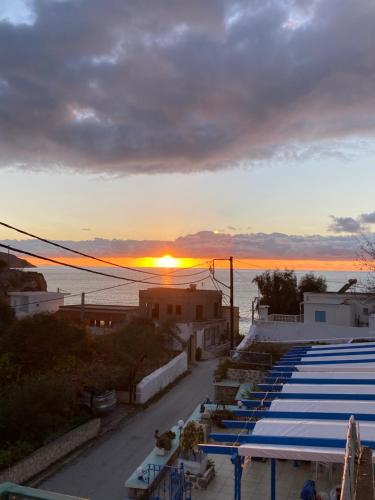 a group of tables with the sunset in the background at Sevasti Studios in Panormos Kalymnos