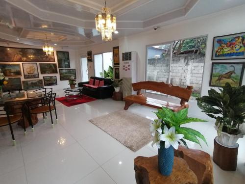 uma sala de estar com um vaso de flores sobre uma mesa em Sillero Painting Gallery and Hostel em Dumaguete
