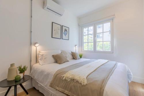 Un dormitorio blanco con una cama grande y una ventana en Studio en la Calle Monjitas Corazon de Santiago, en Santiago