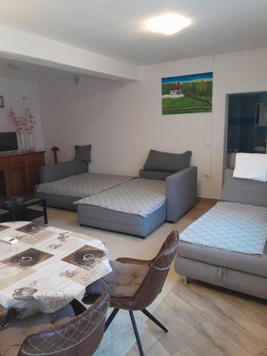 ein Wohnzimmer mit einem Sofa und einem Tisch in der Unterkunft apartmaj strunjan in Portorož