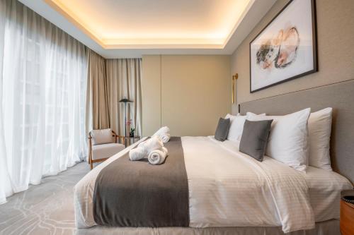 a hotel room with a large bed and a chair at Address Opera Residences Burj Khalifa View in Dubai