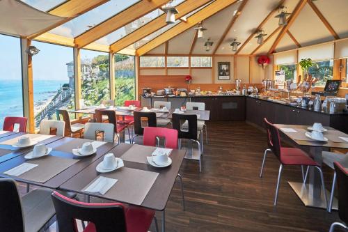 a restaurant with tables and chairs and a bar at Mercure Granville Le Grand Large in Granville