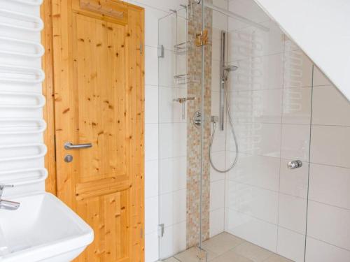 een badkamer met een douche en een houten deur bij Holiday home Zinnwald large in Kurort Altenberg