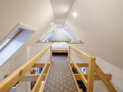 Cette petite chambre mansardée comprend un lit et des escaliers. dans l'établissement Exclusive tiny house, à Buxtehude