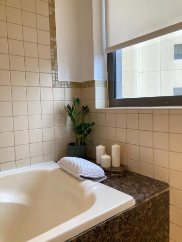 a bath tub in a bathroom with a potted plant at Jumeirah Beach Residence in Dubai