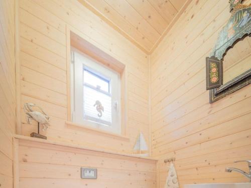 Baño de madera con ventana y lavabo en The Goose Modern Retreat, en Burgstaaken