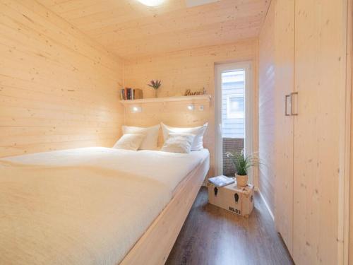 Un dormitorio con una cama grande en una habitación de madera. en The Goose Modern Retreat, en Burgstaaken