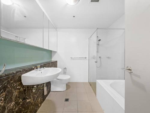 a bathroom with a sink and a toilet and a shower at City 3bd Oasis in Sydney