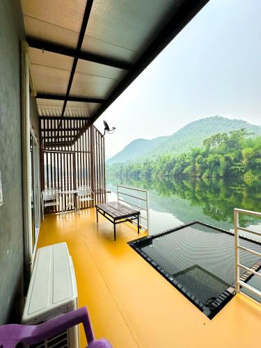 a balcony of a boat with a view of a river at ชอว์ งาทอง รีสอร์ต Chor Ngar Thong Erawan Kanchanaburi in Kanchanaburi