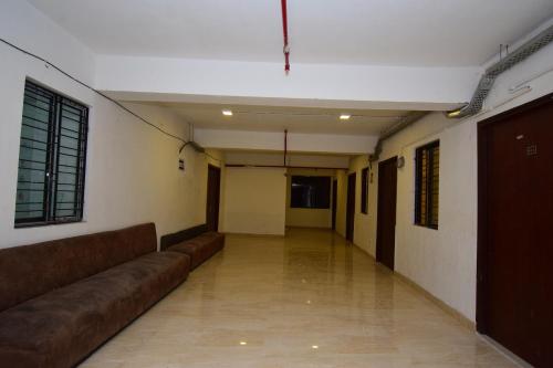 OYO Flagship Bengal Inn في Sānkrāil: ممر فارغ مع اريكه في الغرفه