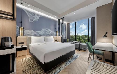 a hotel room with a bed and a desk and a table at Hyatt Place Makassar in Makassar