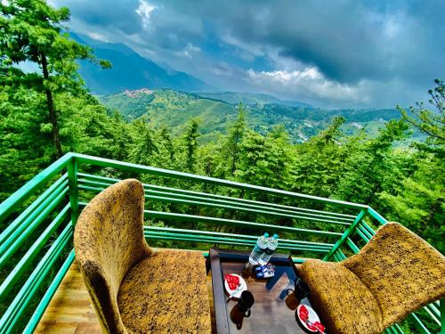 2 sedie e un tavolo sul balcone con vista di Nature Valley Resort -- A Four Star Luxury Resort a Shimla