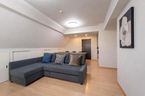 a living room with a blue couch in a room at ACROSS Akihabara in Tokyo