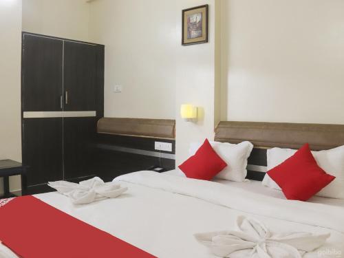 a bedroom with two beds with red and white pillows at Hotel Elegant in Dimāpur
