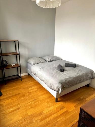 a bedroom with a bed and a wooden floor at Appartement Entier Montespan - Parking Privé in Évry-les-Châteaux