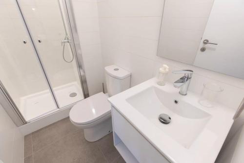 a white bathroom with a toilet and a sink at Estancia memorable en Santiago Depto 2D2B in Santiago