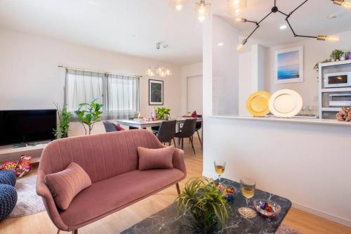 a living room with a couch and a table at 敷地内でBBQができてビーチまで車で5分の好立地　最高の沖縄滞在をN. HOUSEでどうぞ in Tokeshi