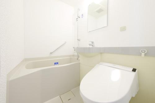 a white bathroom with a toilet and a sink at APA Hotel Midosuji Hommachi Ekimae in Osaka