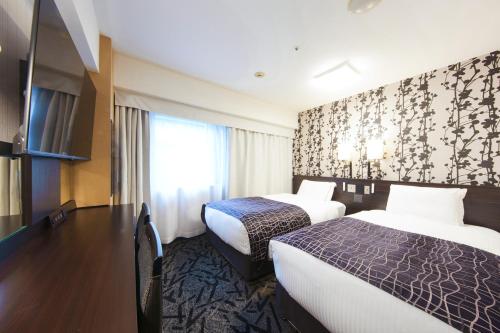 ein Hotelzimmer mit 2 Betten und einem Fenster in der Unterkunft APA Hotel Midosuji-Honmachi-Ekimae in Osaka