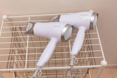 a white hairdryer hanging on a wall at 敷地内でBBQができてビーチまで車で5分の好立地　最高の沖縄滞在をN. HOUSEでどうぞ in Tokeshi