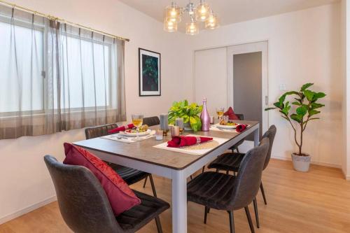a dining room with a table and chairs at 敷地内でBBQができてビーチまで車で5分の好立地　最高の沖縄滞在をN. HOUSEでどうぞ in Tokeshi