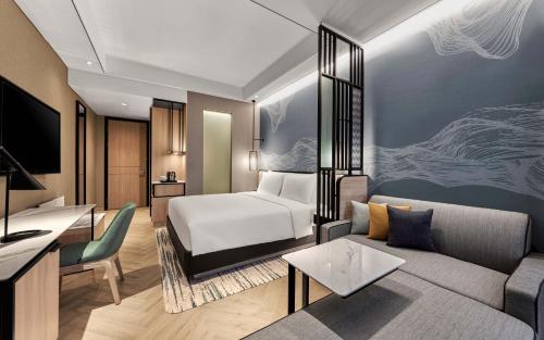 a hotel room with a bed and a couch at Hyatt Place Makassar in Makassar