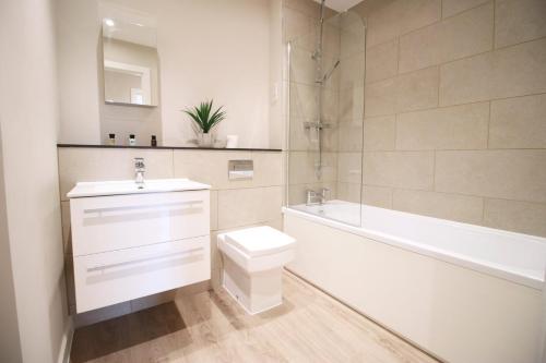 W łazience znajduje się toaleta, umywalka i wanna. w obiekcie Casablanca 18 - Cardiff Bay - 2 Bed Apartment w Cardiff