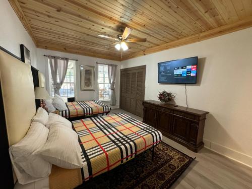 1 Schlafzimmer mit 2 Betten und einem Flachbild-TV in der Unterkunft Secluded Turn of the Century Estate Home - 4 acres in Memphis