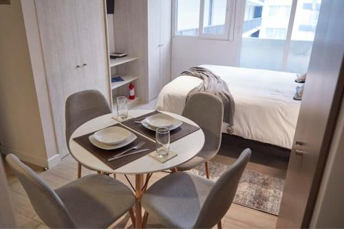 een tafel en stoelen in een kamer met een bed bij Comodo Departamento Studio en Centro de Santiago in Santiago