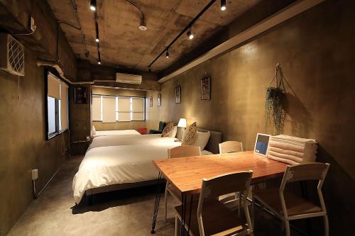 a bedroom with a bed and a table with a laptop at KANDA HOUSE!! Shin-Okubo Walkable Modern Stay with Shinjuku Access in Tokyo