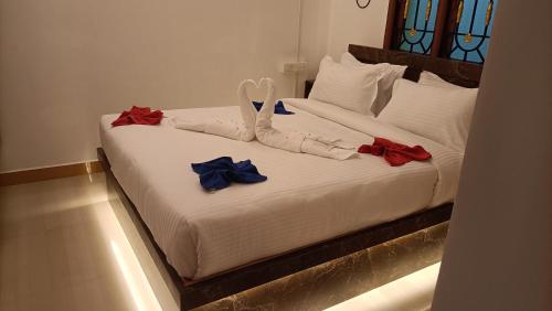 a bed with red and blue bows on it at La Shashalia Luxury in Puducherry