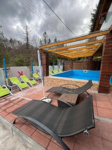 a patio with chairs and a swimming pool at Gasthaus Casa Kugler in Anina