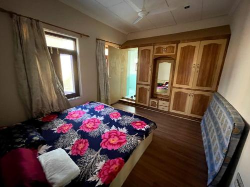 a bedroom with a bed with flowers on it at New Aashiyana Homestay in Baghwānpur