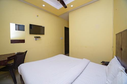 a bedroom with a bed and a tv on the wall at Hotel O Rama Palace in Morādābād
