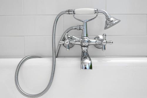 une douche dans une salle de bain avec une pomme de douche dans l'établissement Profitez de la quiétude en bord de rivière, à 5 min du centre ville, à LʼIsle-sur-la-Sorgue