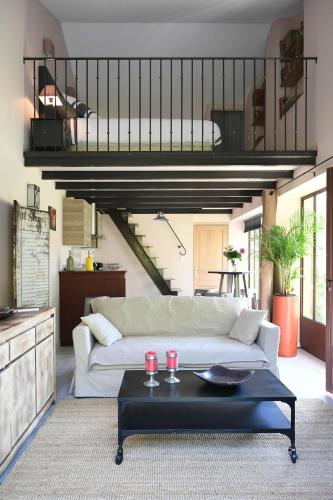 un salon avec un canapé blanc et une table dans l'établissement Profitez de la quiétude en bord de rivière, à 5 min du centre ville, à LʼIsle-sur-la-Sorgue