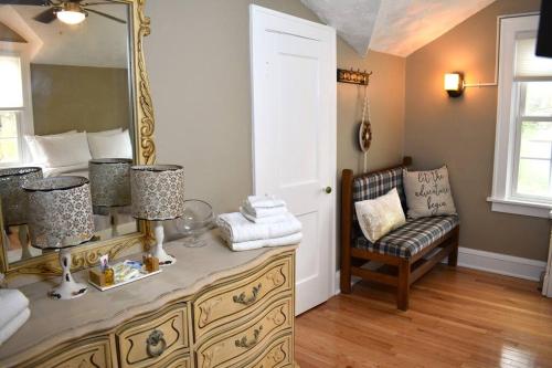 a room with a dresser with a mirror and a chair at The House Hotels - Acadia Farms in Northfield