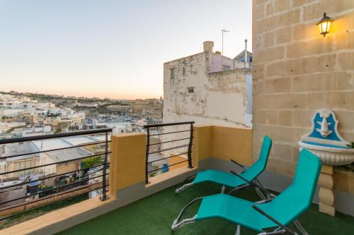 d'un balcon avec deux chaises et une vue sur la ville. dans l'établissement Sunny Maltese townhouse Madonnina Kalkara - Happy Rentals, à Kalkara