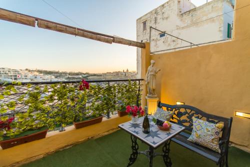 a balcony with a table and a view of a city at Sunny Maltese townhouse Madonnina Kalkara - Happy Rentals in Kalkara