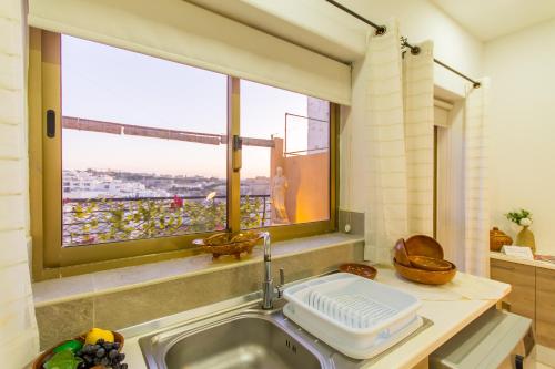 a kitchen with a sink and a window at Sunny Maltese townhouse Madonnina Kalkara - Happy Rentals in Kalkara