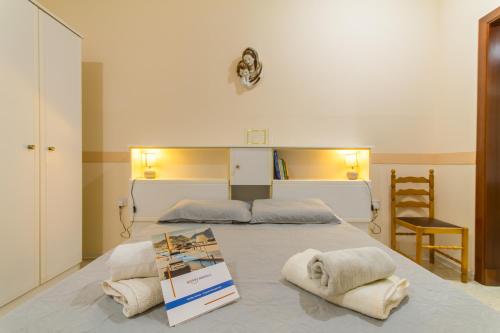 a bedroom with a bed with towels on it at Sunny Maltese townhouse Madonnina Kalkara - Happy Rentals in Kalkara