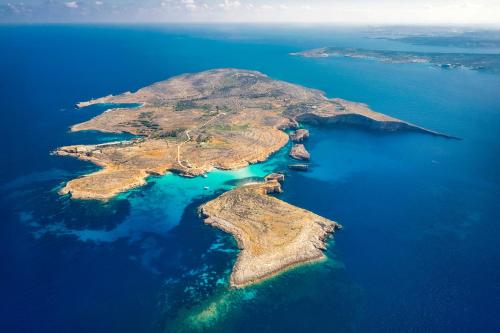 an island in the ocean with blue water at Sunny Maltese townhouse Madonnina Kalkara - Happy Rentals in Kalkara