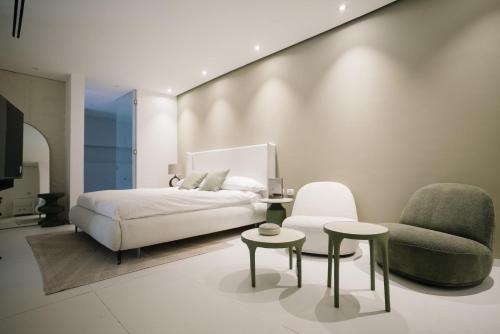1 dormitorio con 1 cama y 1 silla en Lake of Dreams - וילה וסוויטות מושלמות עם בריכה פרטית בים המלח en Neve Zohar