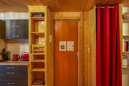 une cuisine avec un rideau rouge et une porte dans l'établissement CIEL MONTAGNARD - Apartment with mountain views, à Annecy