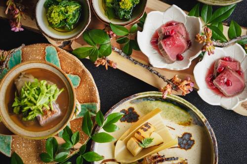 un tavolo con piatti di cibo e ciotole di zuppa di Ochiairo a Izu