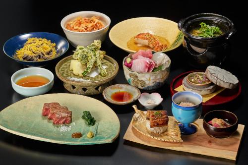 una mesa cubierta con platos y tazones de comida en Ochiairo, en Izu