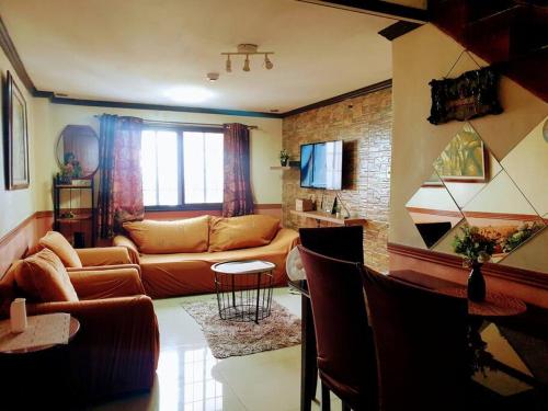uma sala de estar com um sofá e uma mesa em Greenhills Garden Square em Manila
